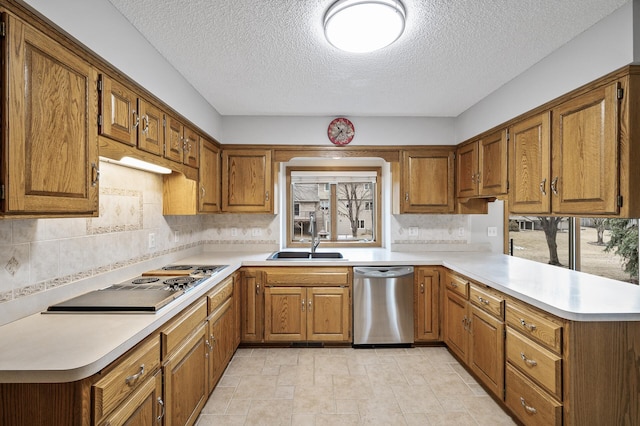 kitchen featuring sink, tasteful backsplash, black electric stovetop, stainless steel dishwasher, and kitchen peninsula