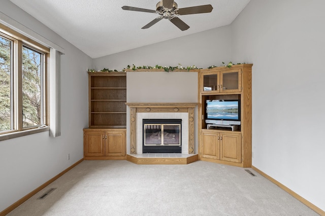 unfurnished living room with light colored carpet, a fireplace, vaulted ceiling, and a textured ceiling