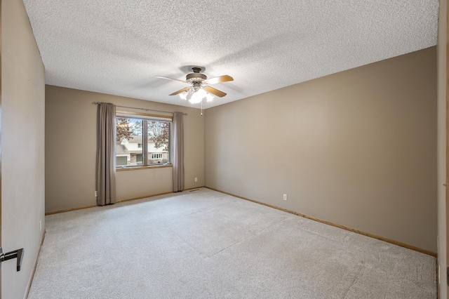 carpeted empty room featuring ceiling fan and a textured ceiling