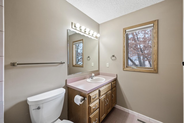 bathroom with vanity, a textured ceiling, and toilet