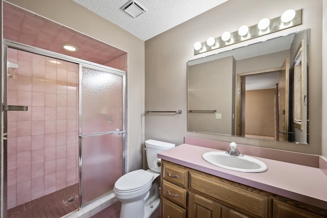 bathroom featuring vanity, toilet, a textured ceiling, and walk in shower