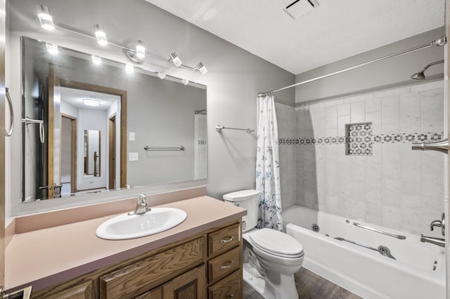 full bathroom featuring shower / tub combo with curtain, wood-type flooring, vanity, toilet, and a textured ceiling