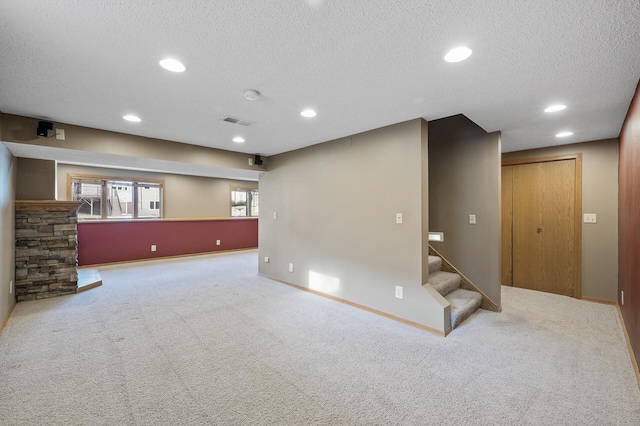 basement featuring carpet, a wealth of natural light, and a textured ceiling