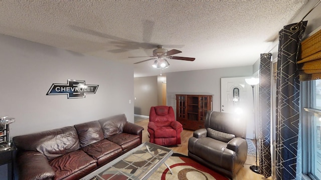 living room featuring ceiling fan and a textured ceiling