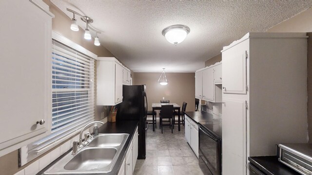 kitchen with a textured ceiling, sink, black appliances, white cabinets, and hanging light fixtures