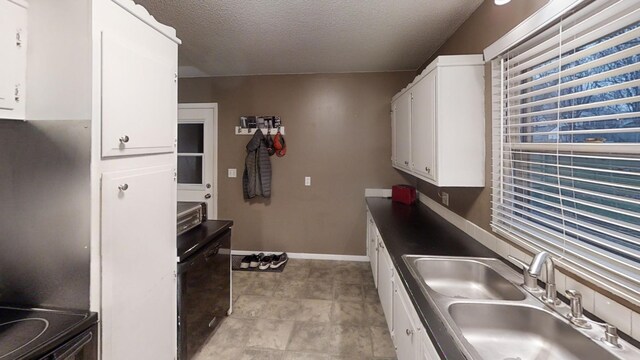 kitchen featuring a textured ceiling, white cabinetry, electric range, and sink