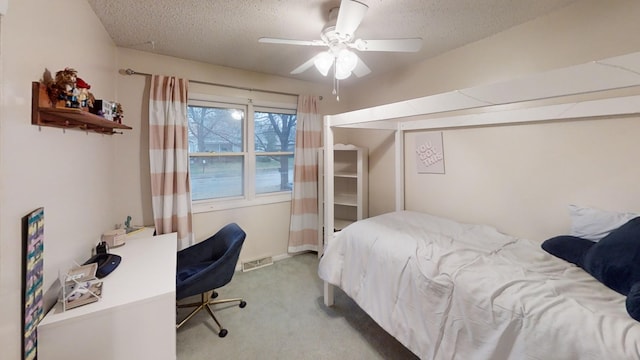 carpeted bedroom with ceiling fan and a textured ceiling