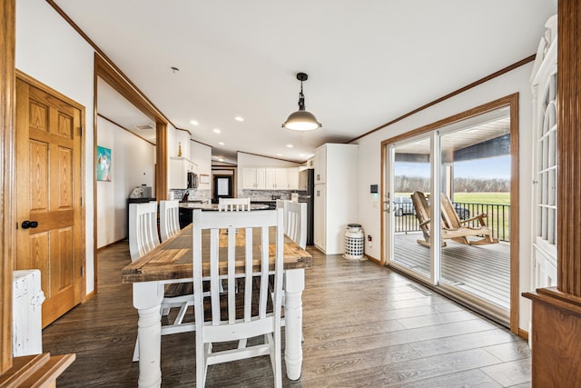 dining area with lofted ceiling, dark hardwood / wood-style floors, and ornamental molding