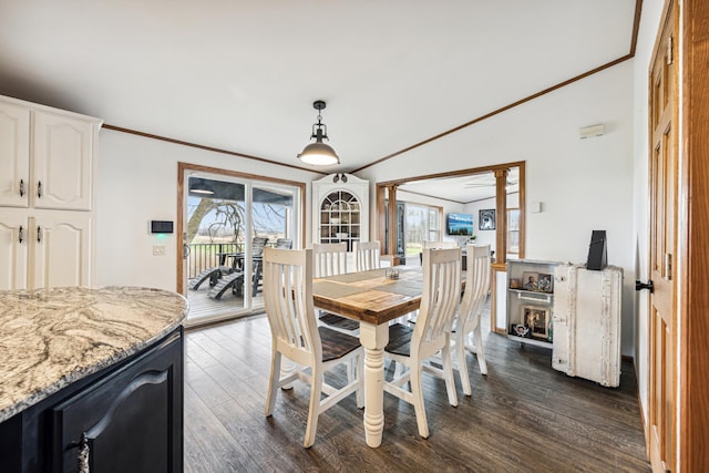 dining space with dark hardwood / wood-style flooring, vaulted ceiling, and crown molding