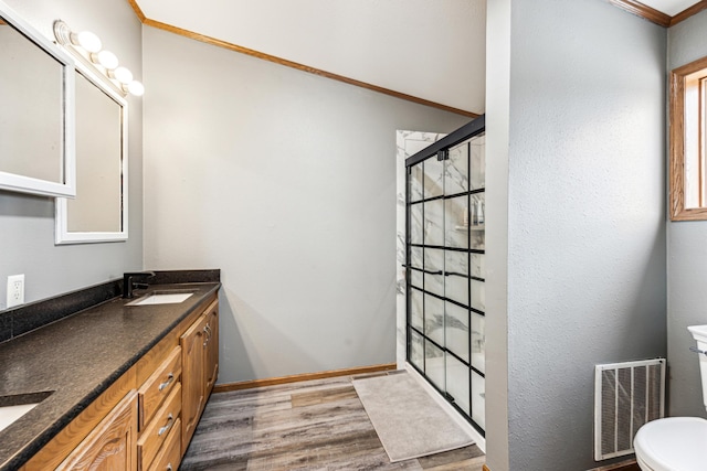 bathroom featuring vanity, crown molding, a shower, hardwood / wood-style floors, and toilet