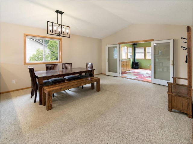 3781 Willowwood St SW, Prior Lake, MN 55372 - dining room featuring a chandelier, vaulted ceiling, carpet, and a wood stove