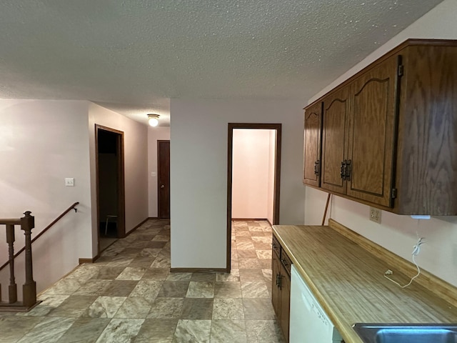 kitchen featuring dishwasher and a textured ceiling