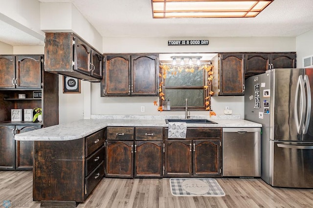 kitchen featuring dark brown cabinetry, sink, stainless steel appliances, and light hardwood / wood-style flooring