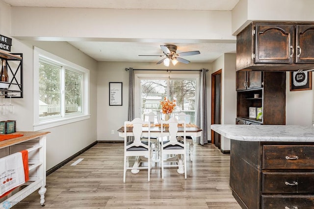 dining space featuring light wood-type flooring, ceiling fan, and a healthy amount of sunlight