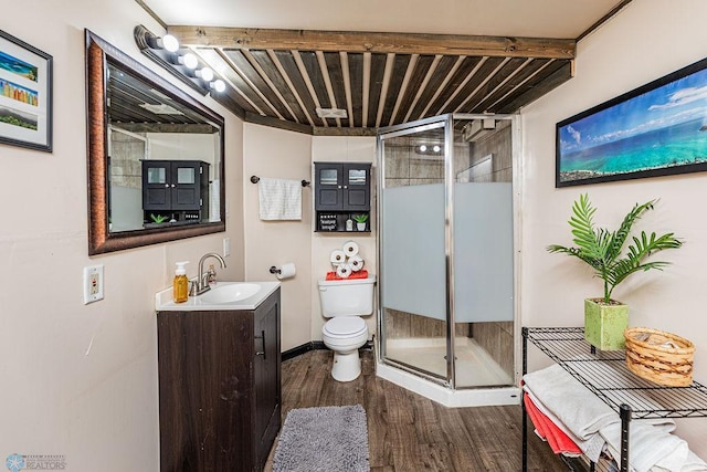 bathroom featuring hardwood / wood-style floors, vanity, toilet, beam ceiling, and an enclosed shower