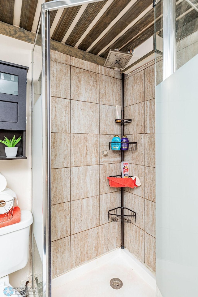 bathroom featuring a tile shower and toilet