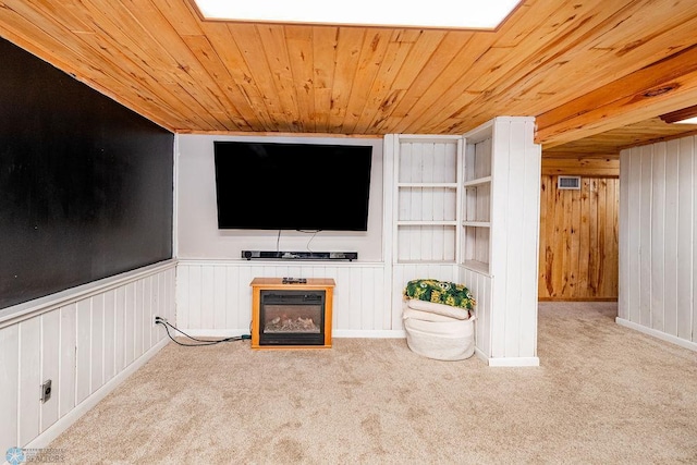 unfurnished living room with wood ceiling, wooden walls, and light colored carpet