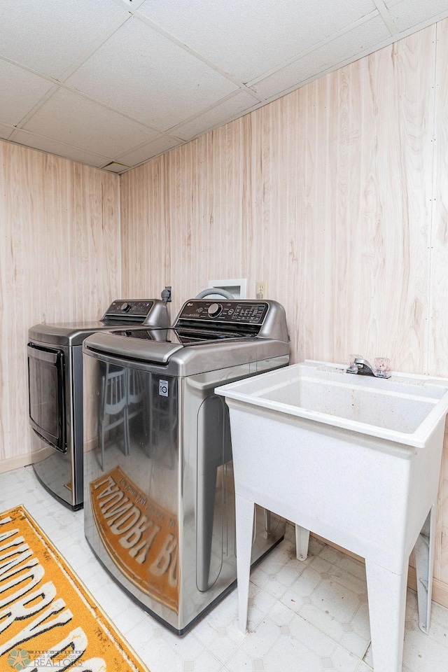 laundry room featuring washing machine and clothes dryer and wooden walls