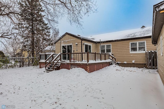 snow covered rear of property featuring a wooden deck