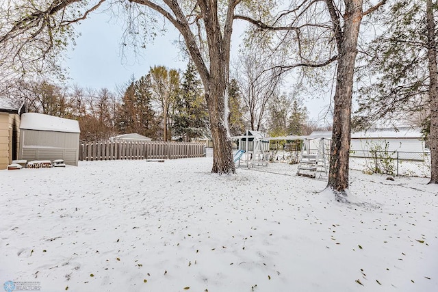 yard layered in snow featuring an outdoor structure