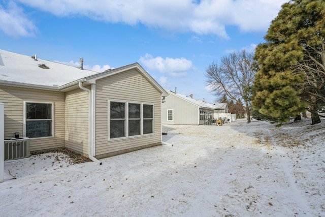 view of snowy exterior with central AC unit