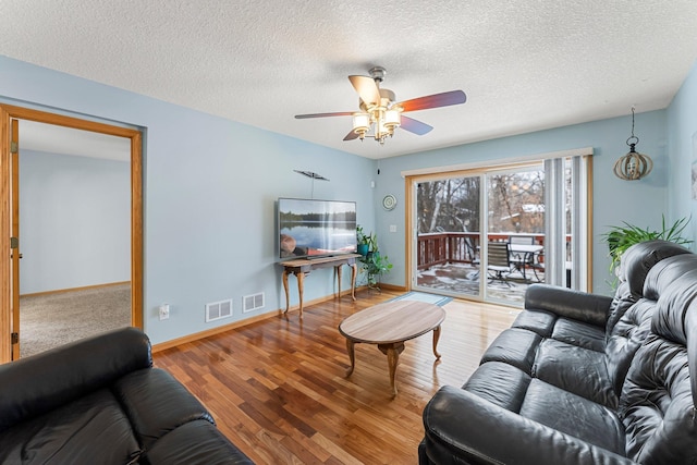 living room with hardwood / wood-style flooring, a textured ceiling, and ceiling fan