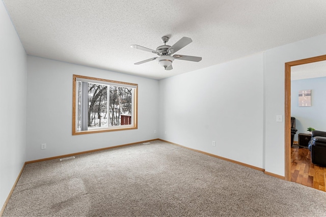 empty room with ceiling fan, carpet, and a textured ceiling