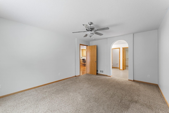 carpeted spare room featuring a textured ceiling and ceiling fan