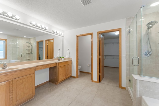 full bathroom featuring tile patterned floors, toilet, shower with separate bathtub, a textured ceiling, and vanity