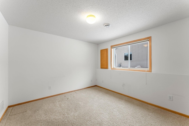 carpeted spare room featuring a textured ceiling