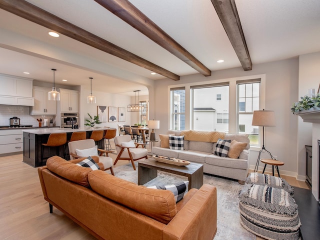 living room featuring beam ceiling and light hardwood / wood-style flooring