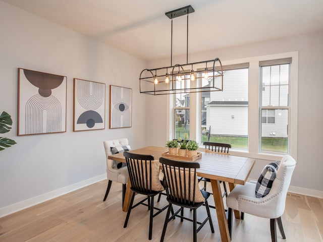 dining room with a chandelier and light hardwood / wood-style flooring