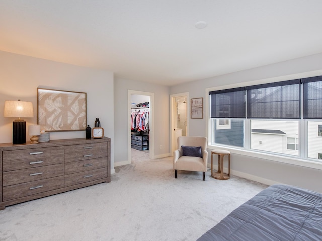 bedroom featuring light colored carpet, a spacious closet, and a closet