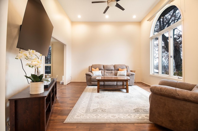 living room with ceiling fan and dark wood-type flooring