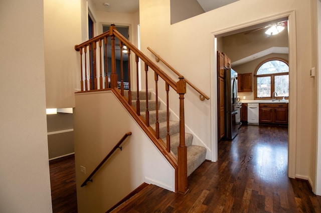 stairway featuring lofted ceiling, ceiling fan, wood-type flooring, and sink