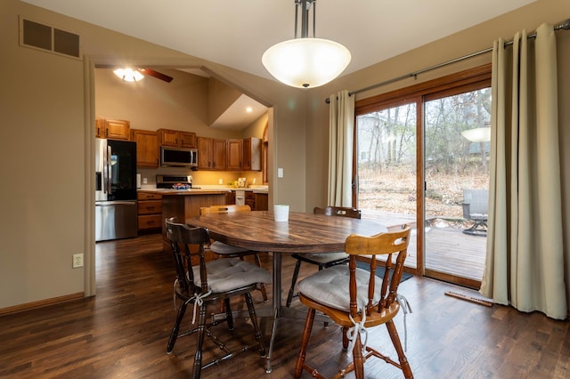 dining space featuring ceiling fan, dark hardwood / wood-style flooring, and vaulted ceiling