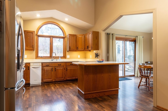 kitchen featuring dark hardwood / wood-style flooring, lofted ceiling, sink, and stainless steel refrigerator