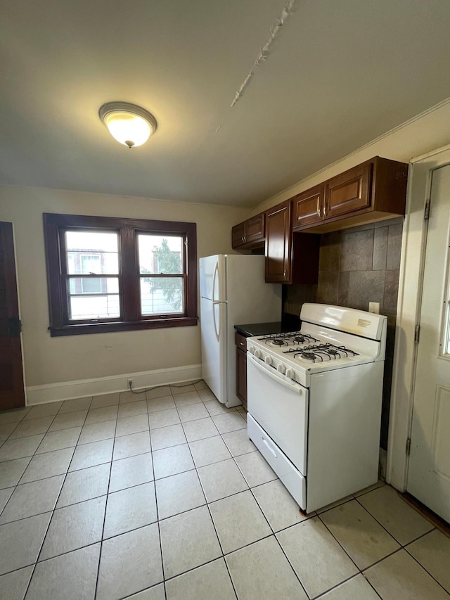 kitchen with light tile patterned floors, white appliances, and tasteful backsplash