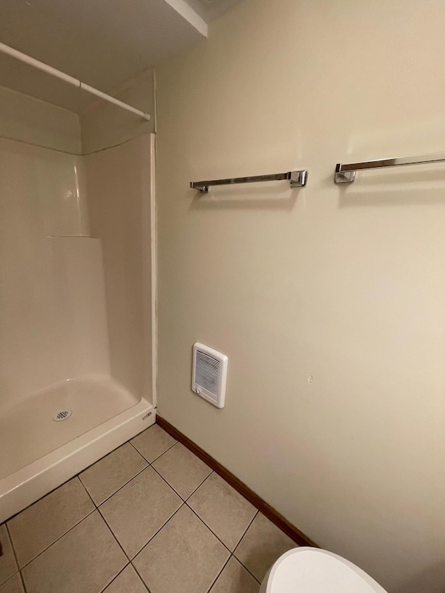 bathroom featuring tile patterned floors, a shower, and toilet