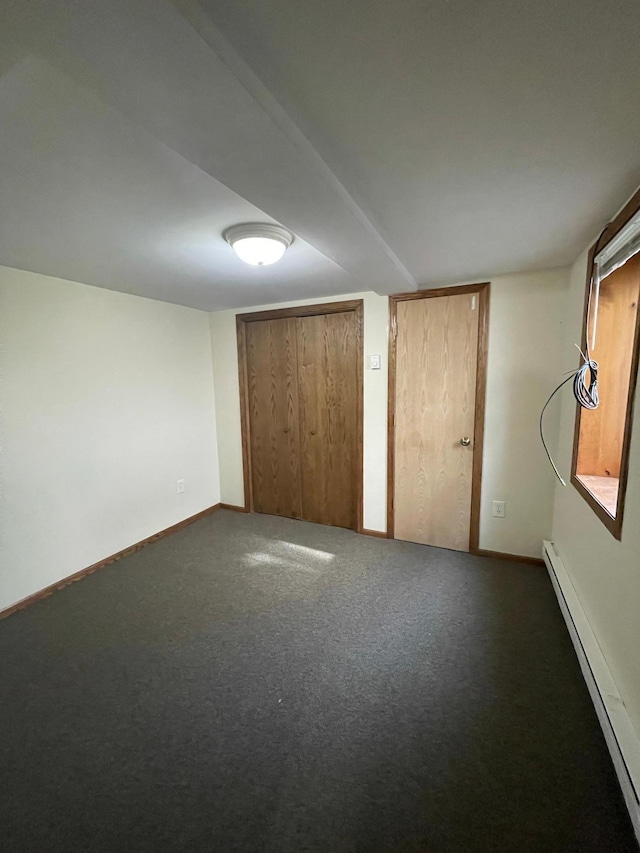 unfurnished bedroom with carpet flooring and baseboard heating