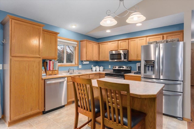 kitchen with sink, stainless steel appliances, pendant lighting, vaulted ceiling, and a kitchen island