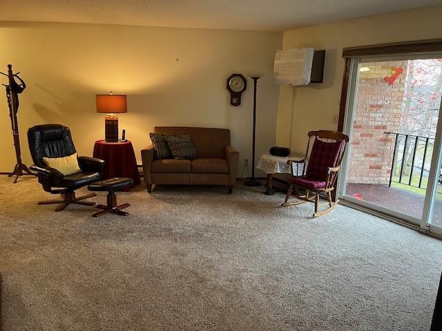 carpeted living room featuring an AC wall unit