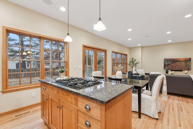 kitchen featuring visible vents, light wood-style flooring, black gas cooktop, and dark stone countertops