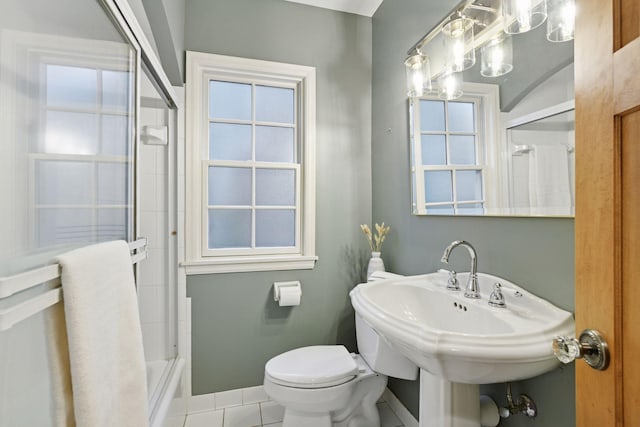 full bathroom with baseboards, bath / shower combo with glass door, toilet, tile patterned floors, and a sink