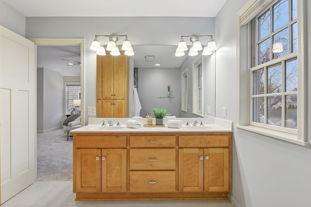 full bath featuring a sink, connected bathroom, baseboards, and double vanity