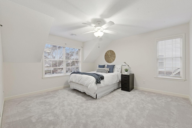 carpeted bedroom featuring a textured ceiling, baseboards, and vaulted ceiling