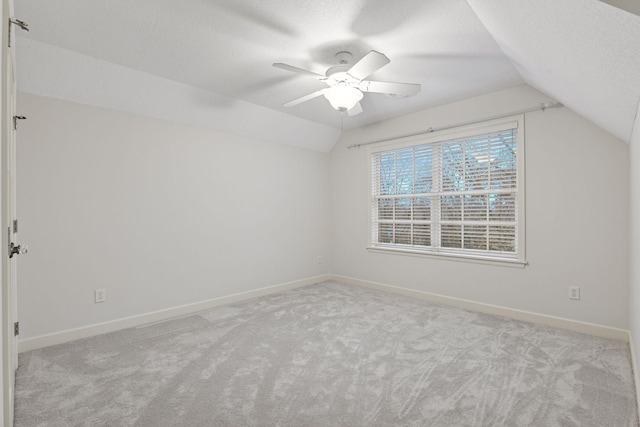 interior space featuring baseboards, lofted ceiling, a textured ceiling, and a ceiling fan