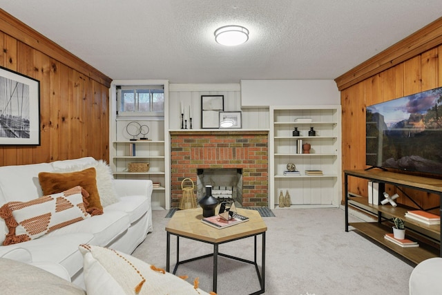 living area with a textured ceiling, a fireplace, carpet flooring, and wood walls