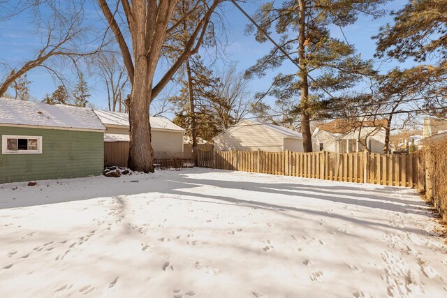 snowy yard featuring a fenced backyard