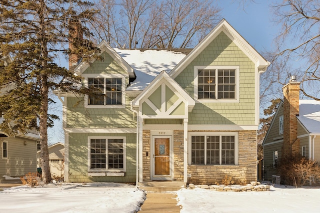 view of front of house featuring stone siding and a chimney